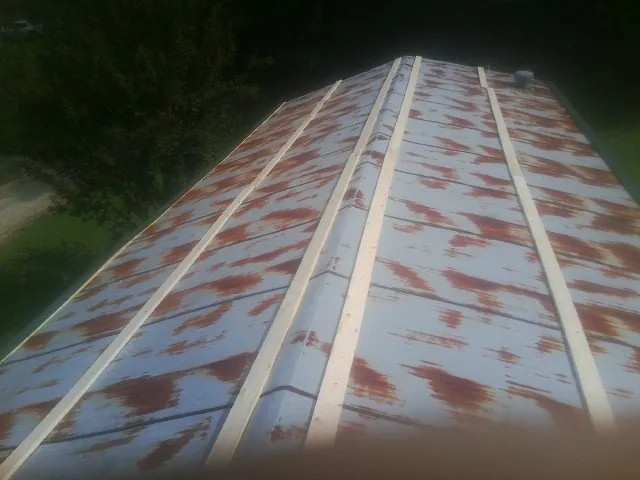Rusted metal roof panels with new wood purlins before replacement — Storm Damage Roof Repair in Slatington by Roofing Brothers