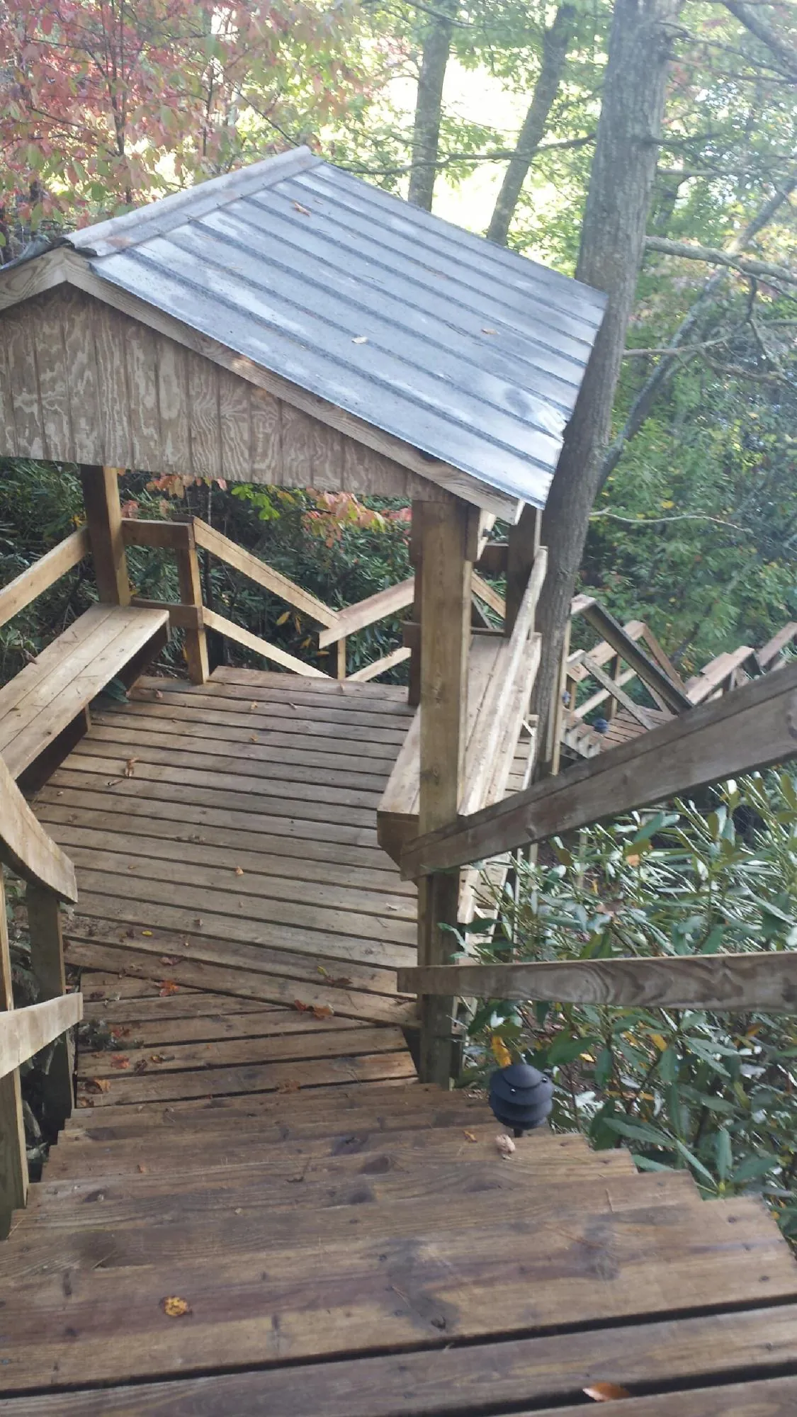 Metal roofed shelter over wooden steps on a wooded walkway — Skylight Repair & Installation work by our crew in Slatington