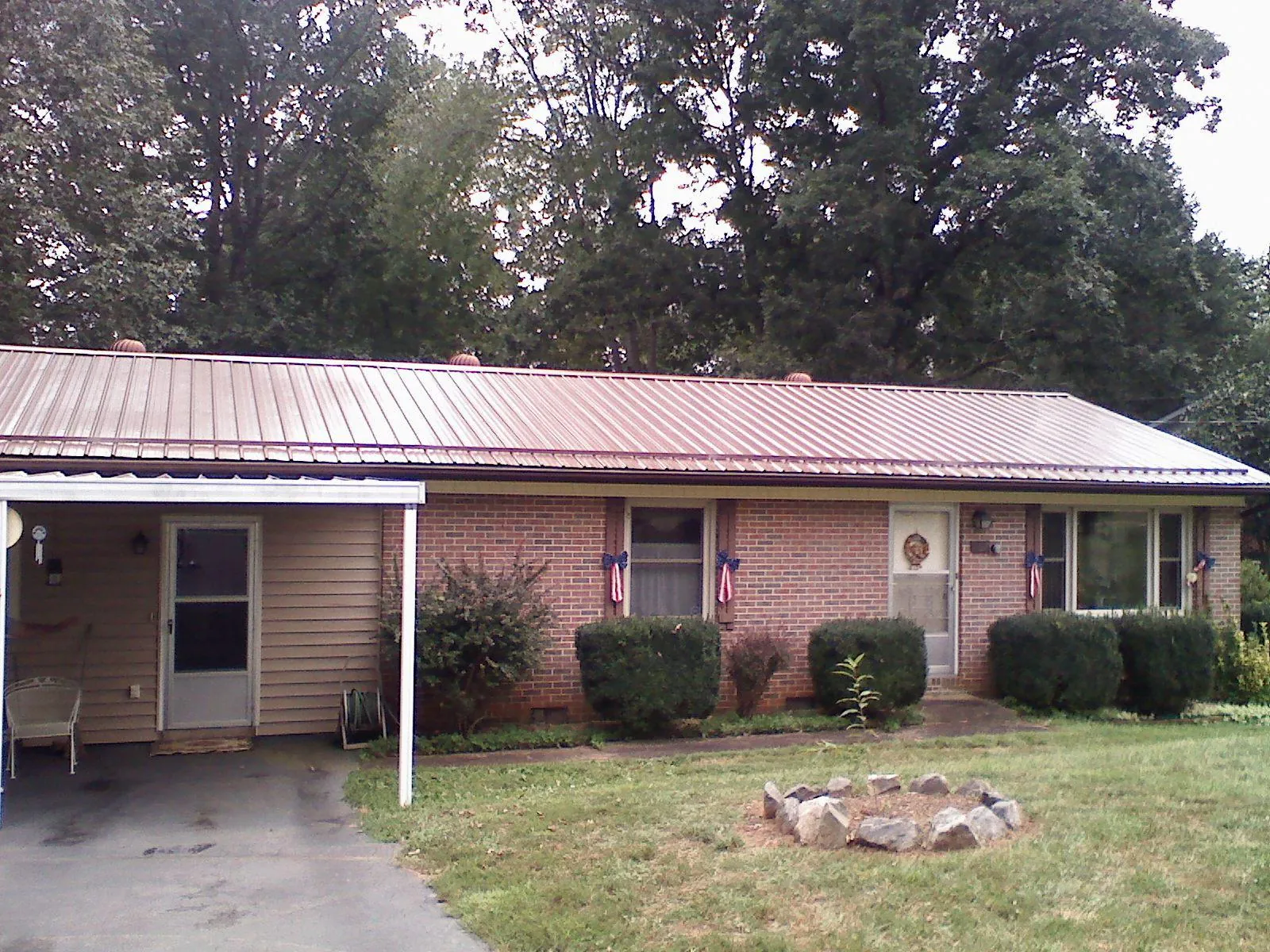 Bronze metal roof and carport on a brick ranch home — Roof Repair work by our crew in Slatington
